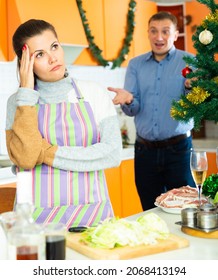 Adult Unhappy Couple Quarreling At Kitchen Decorated For Christmas Celebration