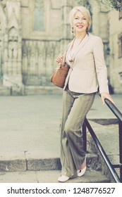 Adult Woman 50s Years Old Is Walking In Classic Dress In Old City.