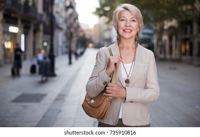 Adult Woman 50s Years Old Is Walking In Classic Dress In Old City.