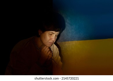 An adult woman asks to help Ukraine. Russian-Ukrainian war stop. The Ukrainian flag next to the face of a woman who screams and prays. - Powered by Shutterstock