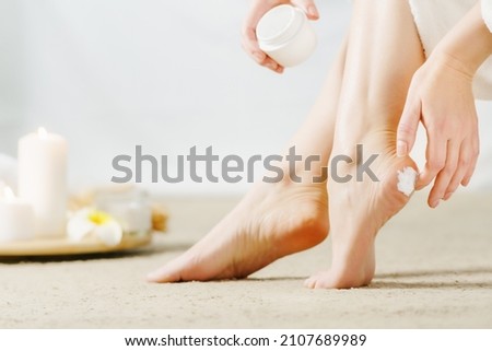 Adult Woman with beautiful feet and cream closeup. Spa treatment. Skincare cosmetic and healthy concept.