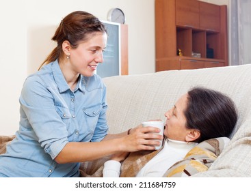  Adult Woman Caring For Sick Mature Mother In Living Room At Home