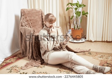 Adult woman with cell phone in room. Middle aged female customer holding smartphone using mobile app, texting message, search commerce offer on phone technology device at homes. Partial focus