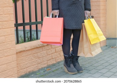 Adult woman with colorful shopping bags in an urban environment