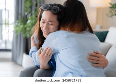 adult woman comforting her friend after bad break up sad asian woman talking with friend on sofa couch in living room love and support friend concept - Powered by Shutterstock