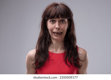 adult woman displays an exaggerated, clear expression of discomfort that borders on fear. She's deeply agitated by bad news, yearning for help and solutions to a grave situation