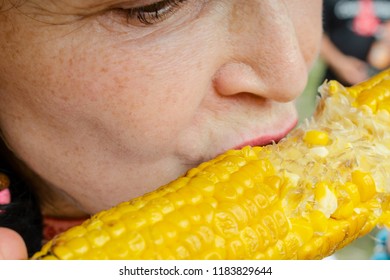 Adult Woman Eats A Boiled Sweet Corn On The Cob With An Appetite. Close-up.