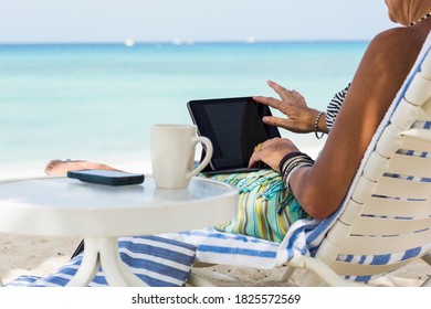 adult woman executive using laptop on the beach, Grand Cayman Island - Shutterstock ID 1825572569