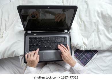 Adult Woman With Glasses, Working At Home Working At Home In Her Pijama With A Laptop And A Mobile Phone. Work From Home Concept