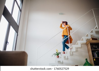 Adult woman going downstairs at home - Lovely woman cheerful on staircase