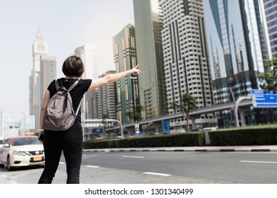 Adult woman hailing taxi in downtown city. - Powered by Shutterstock