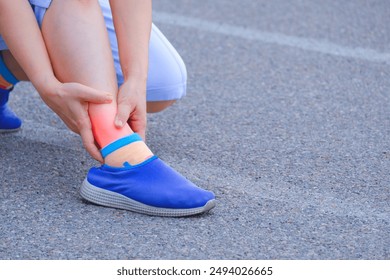 Adult woman hand holding ankle on the running track after injuring her ankle during jogging at sport field  - Powered by Shutterstock