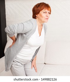 Adult Woman Has A Backache. Mature Female Has Pain In Back