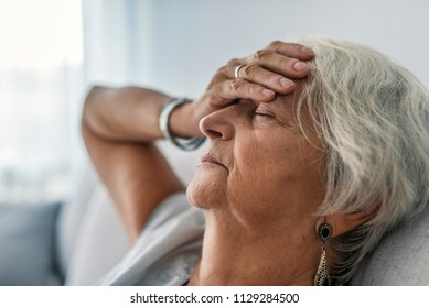 Adult Woman Has A Headache. Sad Mature Female. Anxiety. Anxiety Giving Her A Headache. Older Woman With Hand On Face