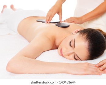 Adult  woman having hot stone massage in spa salon. Beauty treatment concept.