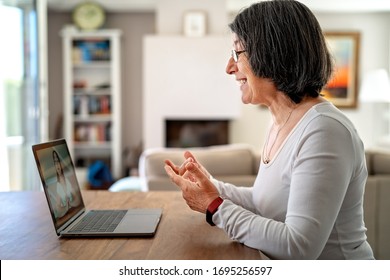 Adult  Woman Having Video Chat Online On Laptop With Her Granddaughter At Home During Quarantine Isolation Pandemic.  Senior Lifestyle. Teacher Giving Online Lesson To Student From Home. 