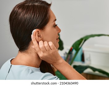 Adult Woman With Hearing Aid Behind The Ear Can Hear Sounds. Hearing Loss Treatment Concept And Hearing Solutions For People With Deafness