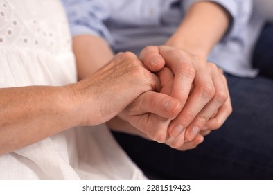 An adult woman holding an elderly mother-grandmother by the hands. Close-up. The concept of love and care. - Shutterstock ID 2281519423