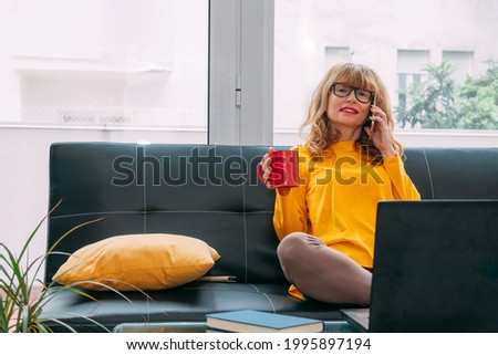 adult woman at home with mobile phone and computer
