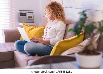 Adult Woman At Home In Smart Working With Computer Laptop Sit Down On The Sofa Writing And Enjoying Technlogy And Communication Device - Beautiful People Female In Video Conference Job Activity