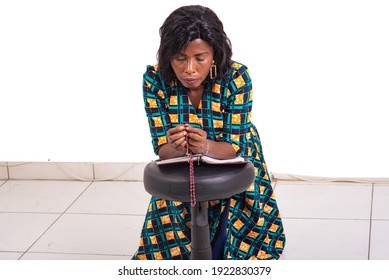 Adult Woman Kneeling Praying With Rosary And Holy Bible In Church.