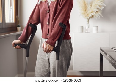 Adult Woman On Crutches At Home. Fracture Of The Leg Or Foot. Concept Of Rehabilitation And Healing. Orthopedics And Traumatology. Unrecognized Person