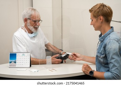 Adult Woman Paying For Visit In Dentist Office In The Medical Clinic With Card.