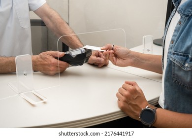 Adult Woman Paying For Visit In Dentist Office In The Medical Clinic With Card.