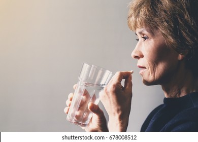 Adult woman with a pill and a glass of water / healthcare concept - Powered by Shutterstock