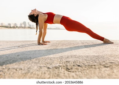 Adult Woman Practising Yoga Exercise By The Sea At Sunset - Athletic Hispanic Female Doing Purvottanasana Position Outdoors - Fitness, Sport And Healthy Lifestyle Concept