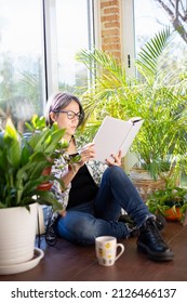 Adult Woman Reading A Book On Garden Terrace. Everyday Life At Home Concept.