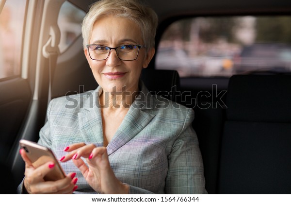 adult\
woman in a suit with a phone in her hand in a\
car