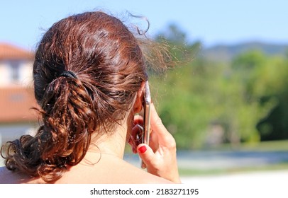 Adult Woman Talking On The Phone Photographed From Behind