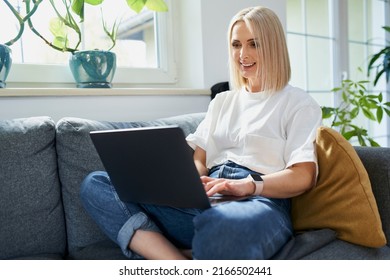 Adult Woman Using Laptop On A Sofa At Home