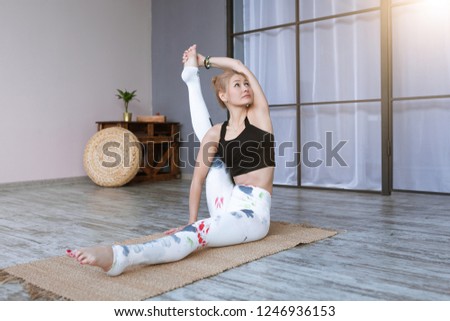 Adult woman wearing training leggings and top working out, doing yoga and pilates exercise, stretching. Healthy lifestyle and wellness
