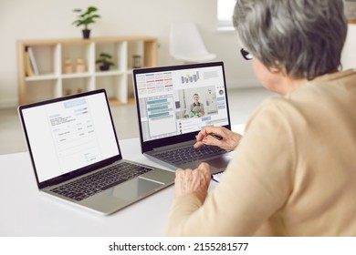 Adult Woman Working On Two Computers. Entrepreneur Sitting At Desk In Front Of Two Laptop Screens, Using Lots Of Modern Apps, Taking Online Business Consultation, Getting Help With Electronic Document