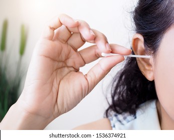 Adult Women Use Cotton Buds Spinning Earwax. Close-up Hand Cleaning Ear With Cotton Swap.