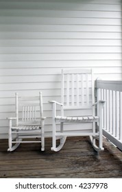 An adult's and child's rocking chairs on a front porch.