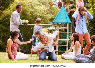 Adults And Kids Having Fun Playing In A Garden