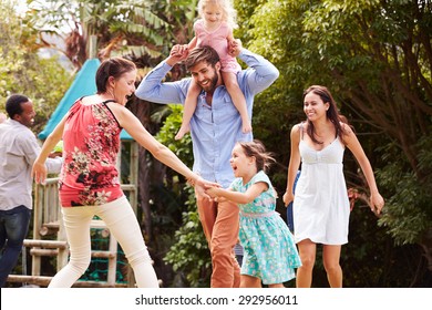 Adults And Kids Having Fun Playing In A Garden