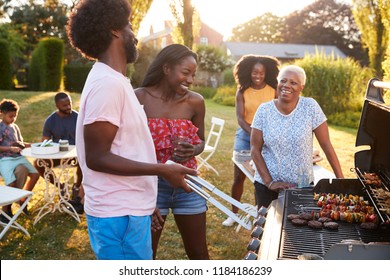 Adults talking at a multi generation family barbecue - Powered by Shutterstock