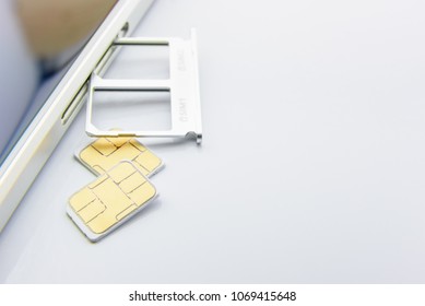 Advanced 5G Mobile Communication Technology Concept : SIM Card Tray / Dual SIM Card Slot With Two Nano SIM Cards On White Background. A SIM Stores International Mobile Subscriber Identity IMSI Number.