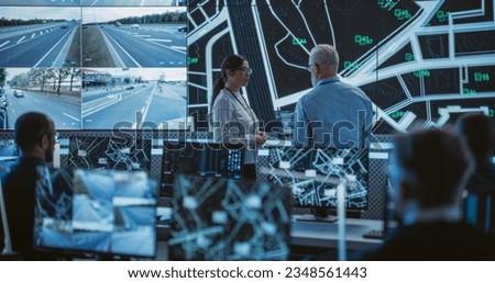 Advanced City Planning Monitoring Center with Diverse Male and Female Officers Analyzing CCTV Footage, Traffic Data and Road Situation on a Big Digital Screen. Team of Specialists Working in Office
