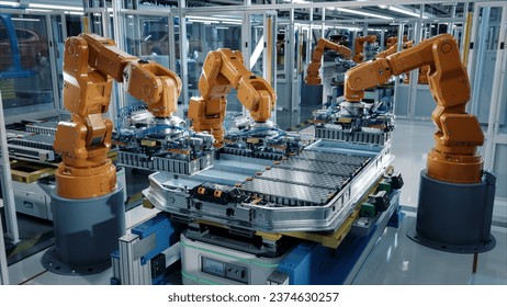 Advanced Orange Industrial Robot Arms Assemble EV Battery Pack on Automated Production Line. Row of Robotic Arms inside Automotive Plant Assemble Batteries. Modern Electric Car Smart Factory.