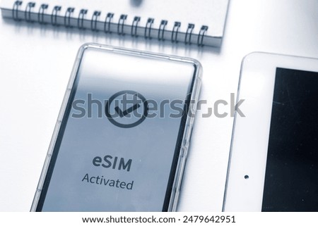 Advantage of eSIM connection for network services concept. A person's mobile phone displaying eSIM activated successfully.