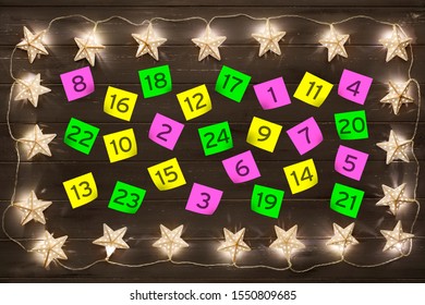 Advent Calander Parer Notes, With A Border Of Golden Star Christmas Lights, On A Distressed Dark Wooden Board Background