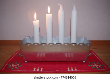 An advent candlestick with two candles lit celebrating second of advent.