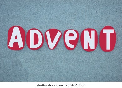 Advent, the first season of the Church year, leading up to Christmas and including the four preceding Sundays, creative text composed with red colored hand painted stone letters over green sand - Powered by Shutterstock