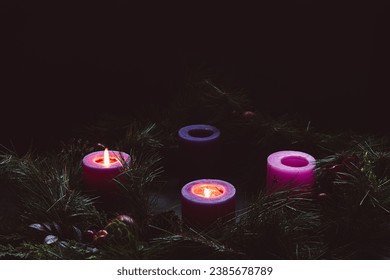 Advent wreath with two candles lit for the second week of advent in a dark room with copy space