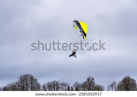 Adventure in the Air: Powered Paragliding Over Winter Landscapes. Gliding Through the Clouds: Paramotor in Action